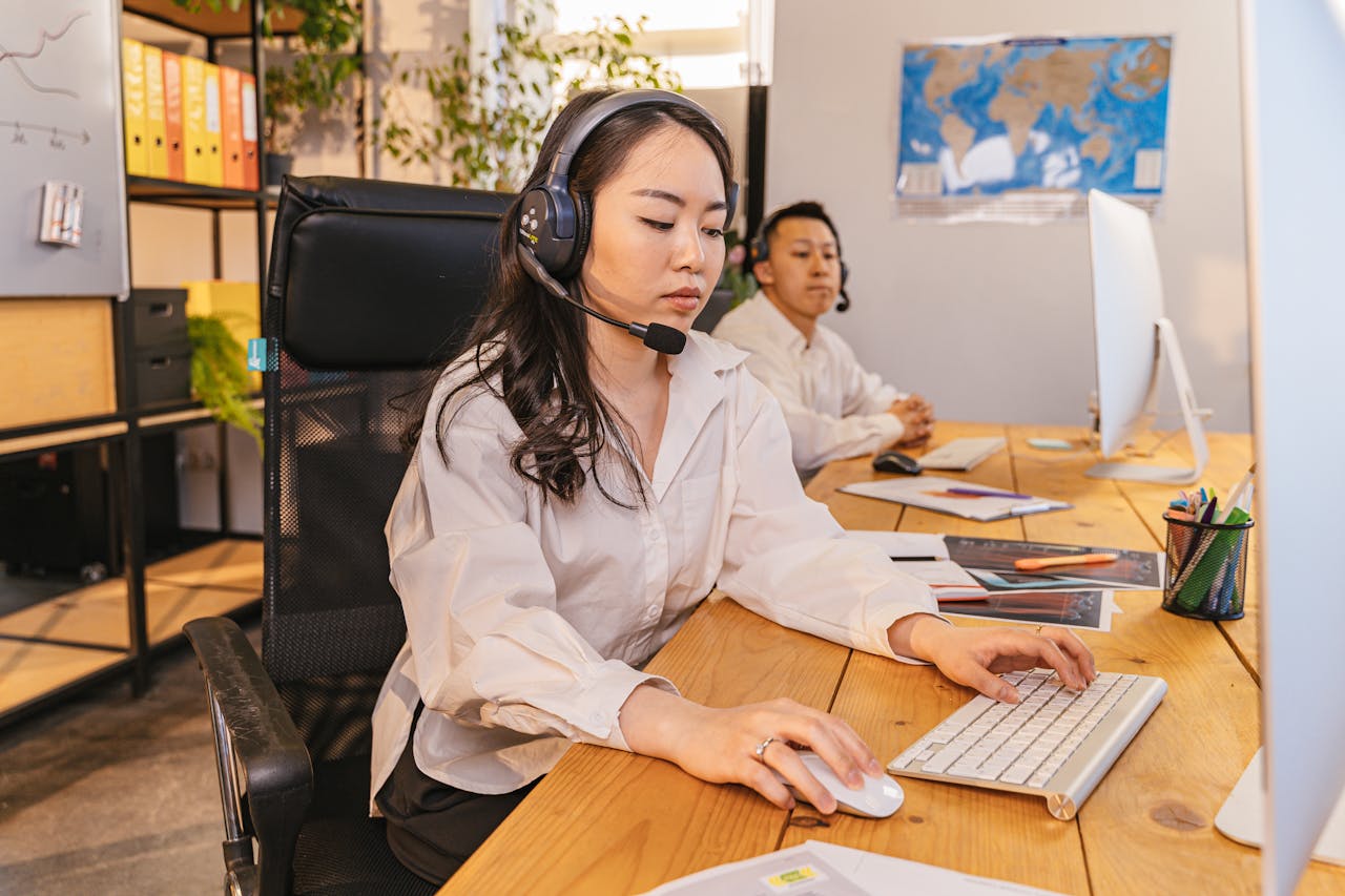 Home Two call center employees working on computers, focused and efficient, in a modern office setting.